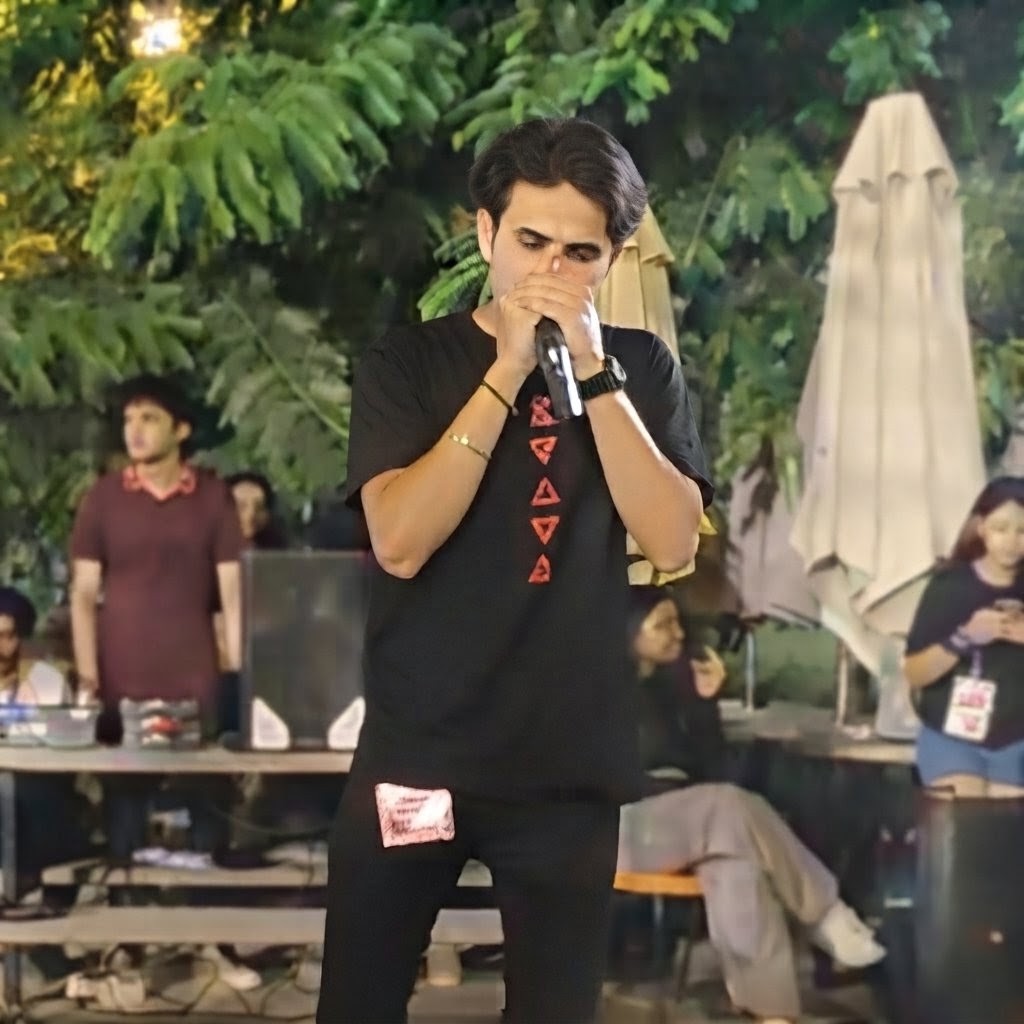 Ishaan Singh Gill beatboxing into a microphone at a live outdoor event