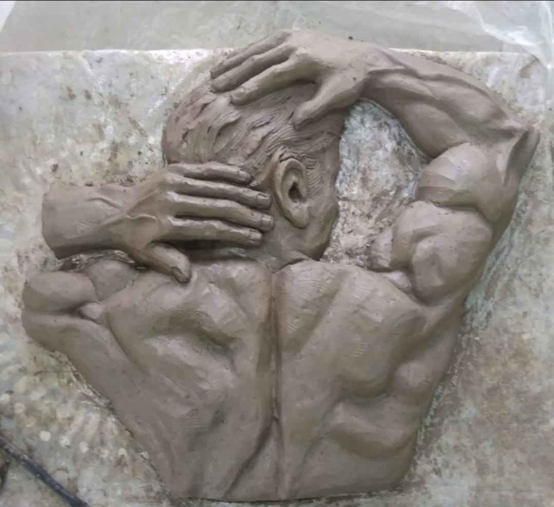 Clay relief of a muscular back with hands behind the head