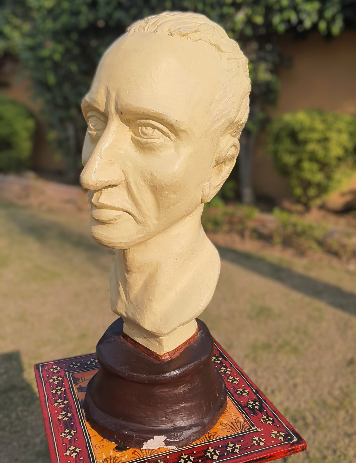 Cream-coloured clay bust of a man in profile
